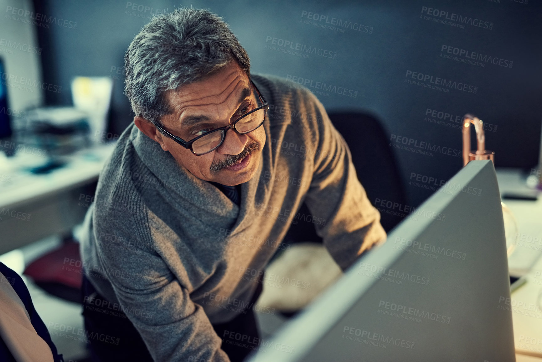 Buy stock photo Shot of a mature businessman working late in an office