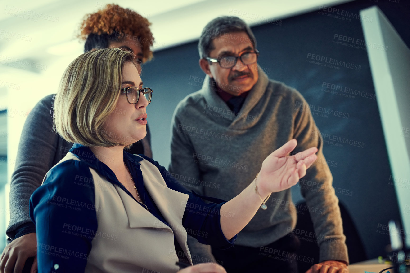 Buy stock photo Shot of a group of businesspeople working late in an office