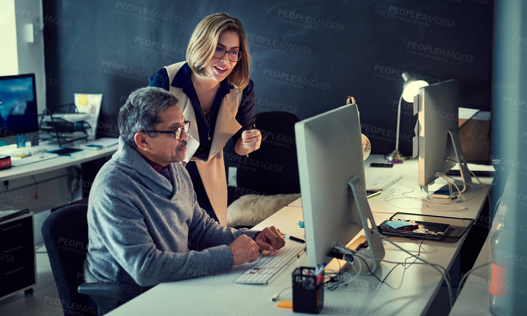 Buy stock photo Shot of two businesspeople working late in an office