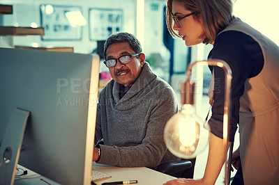 Buy stock photo Shot of two businesspeople working late in an office