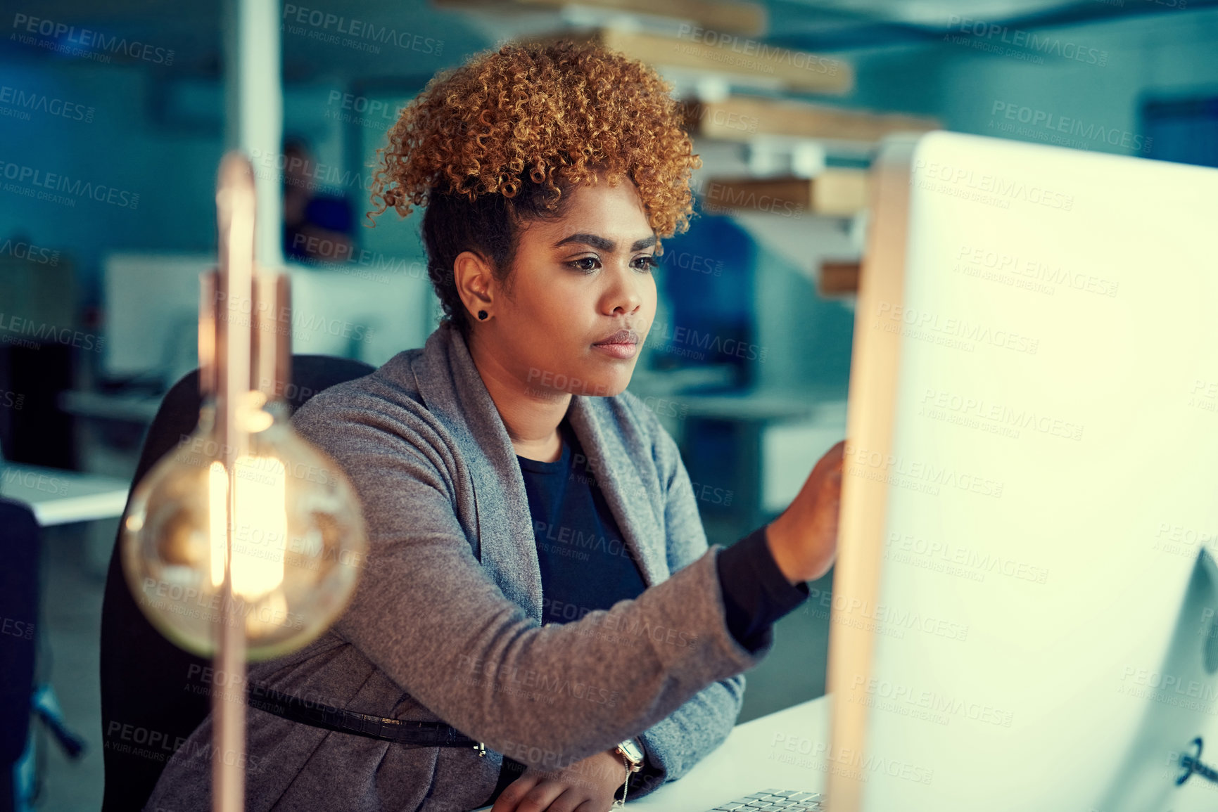 Buy stock photo Shot of a young businesswoman working late in an office