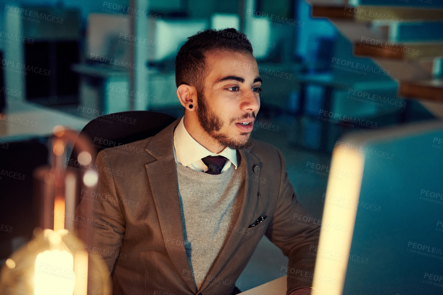 Buy stock photo Shot of a young businessman working late in an office