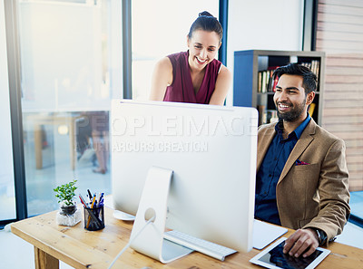 Buy stock photo Cropped shot of two corporate businesspeople working on a computer in the office