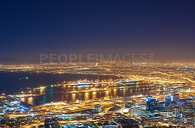 Buy stock photo Copyspace with dark night sky over a cityscape and ocean view in Cape Town, South Africa. Scenic panoramic landscape of lights illuminating a metropolitan skyline in the city centre at night