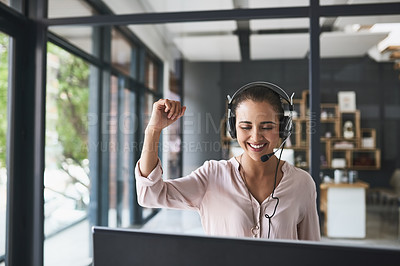 Buy stock photo Shot of a cheerful businesswoman talking to a customer using a headset while having her arm raised