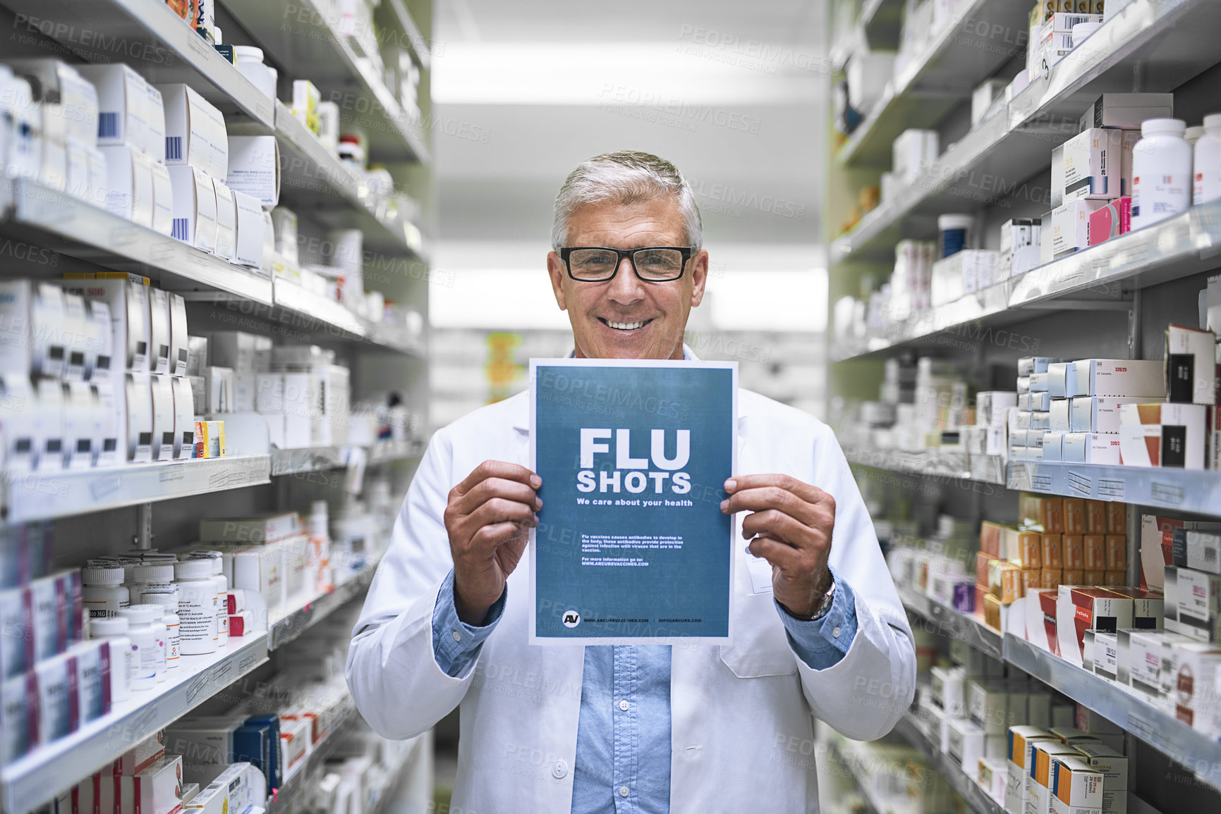 Buy stock photo Portrait of a mature male pharmacist holding up a sign indicating that you can get flu shots there