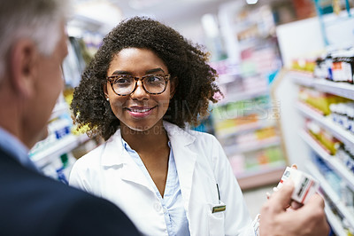 Buy stock photo Shot of a helpful young female pharmacist helping a customer with choosing the right medication in the pharmacy