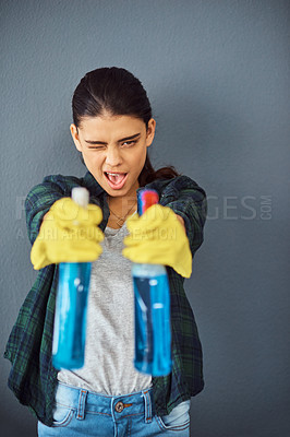 Buy stock photo Portrait, girl and spray with aim for cleaning with playful wink, compliance and maintenance service. Goofy, woman and bottle for fun liquid with sanitize, chemical and hygiene in studio background