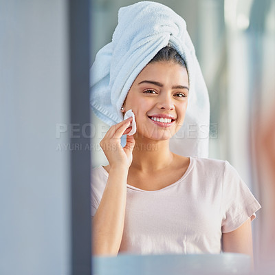 Buy stock photo Cropped portrait of a beautiful young woman exfoliating her skin in the bathroom at home