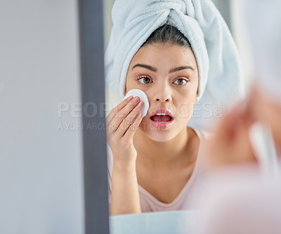 Buy stock photo Cropped shot of a beautiful young woman exfoliating her skin in the bathroom at home