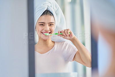 Buy stock photo Cropped portrait of a beautiful young woman brushing her teeth in the bathroom at home