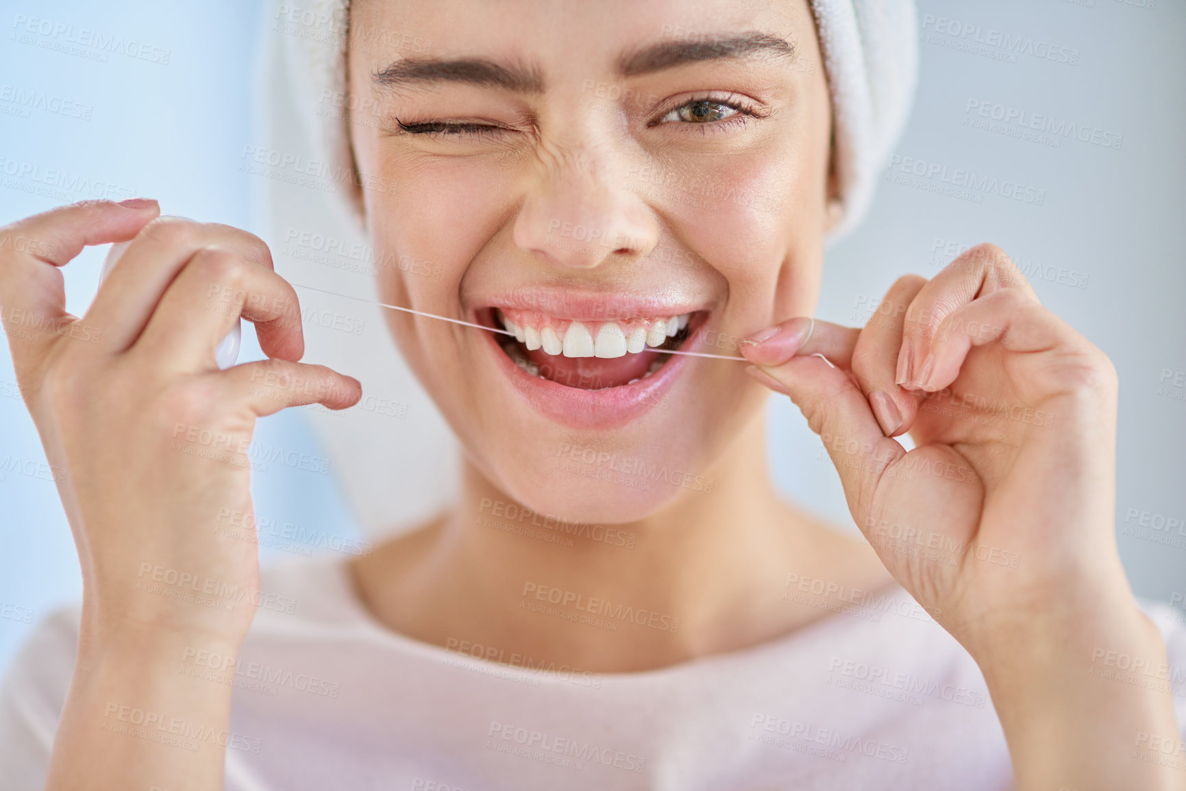 Buy stock photo Cropped portrait of a beautiful young woman flossing her teeth in the bathroom at home