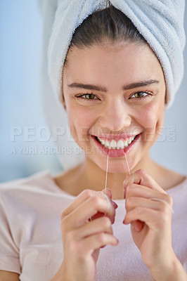 Buy stock photo Cropped portrait of a beautiful young woman flossing her teeth in the bathroom at home