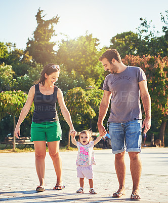 Buy stock photo Happy, walking and parents with baby in park for bonding, loving relationship and relax together outdoors. Family, smile and mom, dad and kid holding hands for fun, playing and affection on weekend