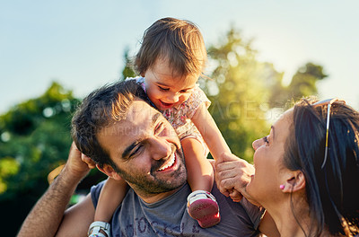 Buy stock photo Family, father and daughter on shoulders in park with happy mom, love and summer sunshine. Young couple, baby girl or laugh together for freedom, bond and helping hand for care, backyard or garden