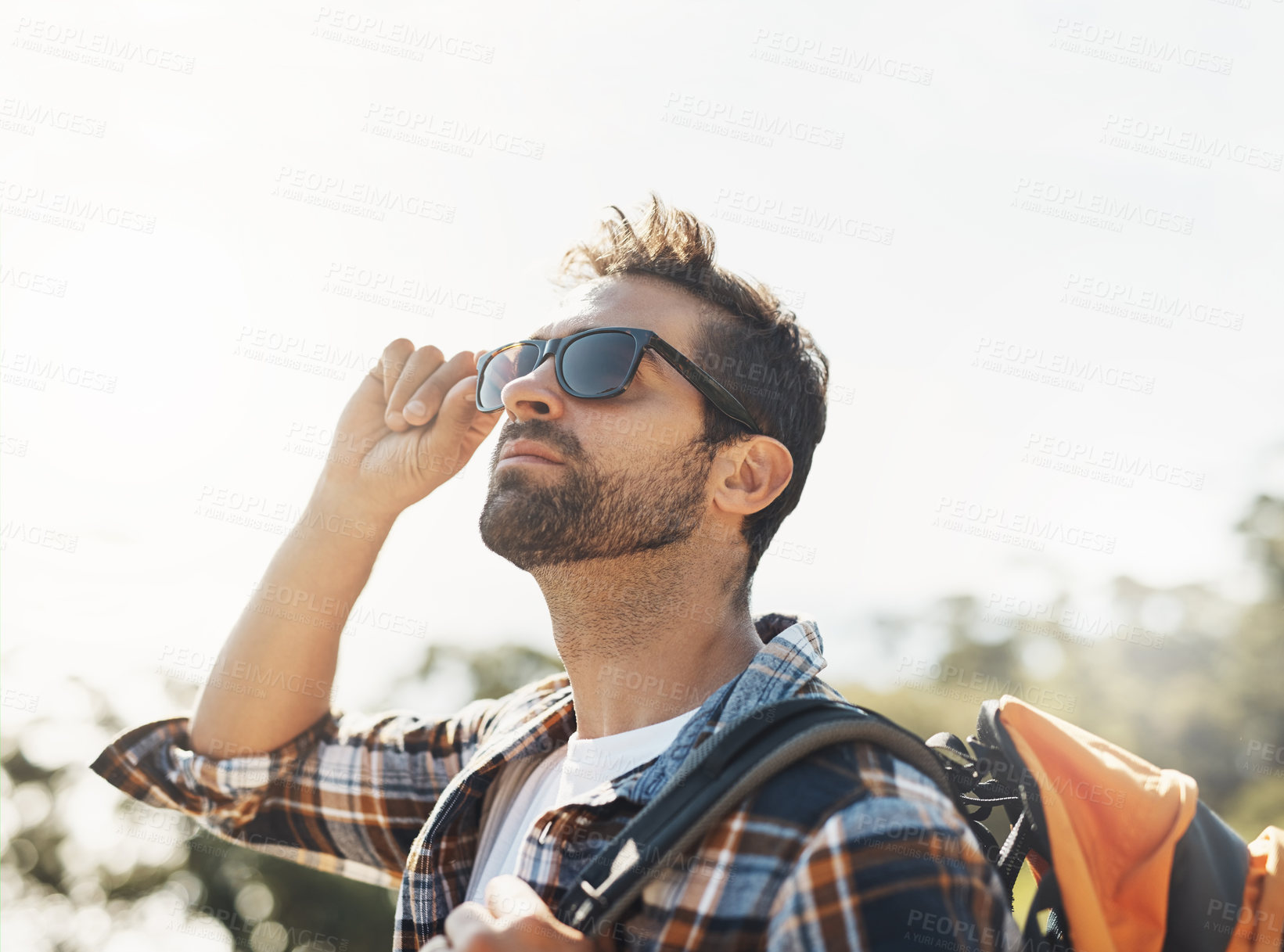 Buy stock photo Cropped shot of a handsome young man hiking in the mountains