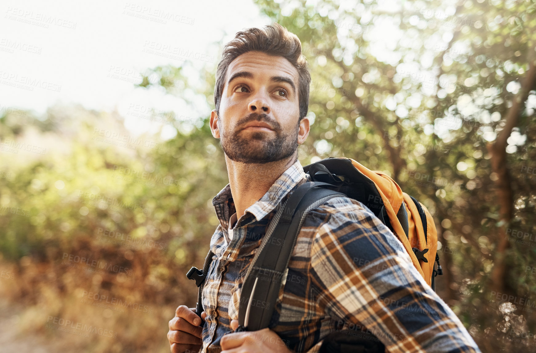 Buy stock photo Cropped shot of a handsome young man hiking in the mountains