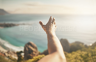 Buy stock photo Cropped shot of an unrecognizable man stretching out his hand towards the view while hiking in the mountains