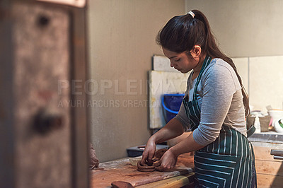 Buy stock photo Shot of a ceramic artist working on her pottery in a workshop