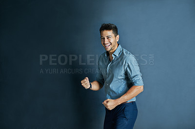 Buy stock photo Celebration, fist pump and portrait of a businessman in a studio with achievement or winning. Happy, smile and professional male employee winner with success to celebrate isolated by blue background.