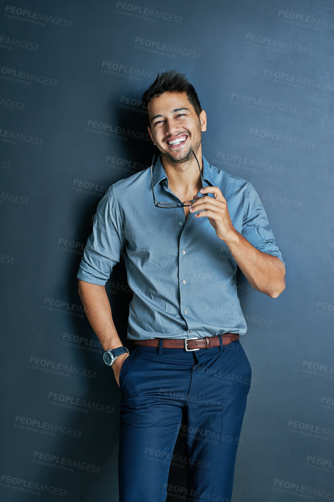 Buy stock photo Portrait of a cheerful young man standing in the studio smiling while looking at the camera