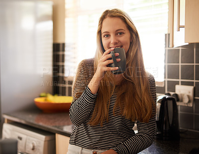 Buy stock photo Shot of a happy young woman enjoying a cup of coffee at home