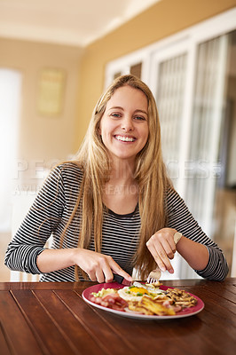 Buy stock photo Shot of a happy young woman enjoying a meal at home
