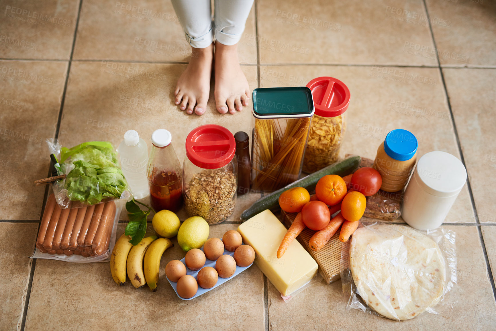 Buy stock photo High angle shot of a woman surrounded by various food in the kitchen at home