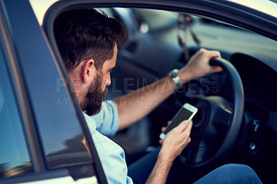 Buy stock photo Cropped shot of a unrecognizable man using his phone while driving to a destination