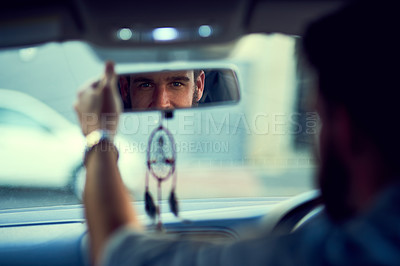 Buy stock photo Rearview shot of a unrecognizable man driving in his car while looking into the rearview mirror