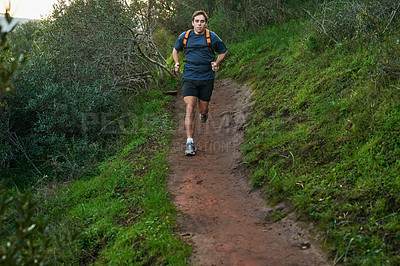 Buy stock photo Full length shot of a handsome male athlete running on a forest trail