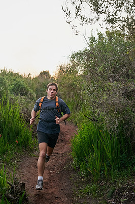 Buy stock photo Full length shot of a handsome male athlete running on a forest trail