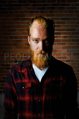 Buy stock photo Man, portrait and serious fashion by brick wall, pride and flannel or plaid style for trend. Male person, tough attitude and farmer or casual outfit for aesthetic, designer clothes and weekend travel