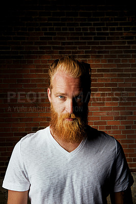 Buy stock photo Man, portrait and serious for clothes by brick wall, pride and shirt for style in outdoor. Male person, tough attitude and confident casual outfit for aesthetic, designer fashion and weekend travel