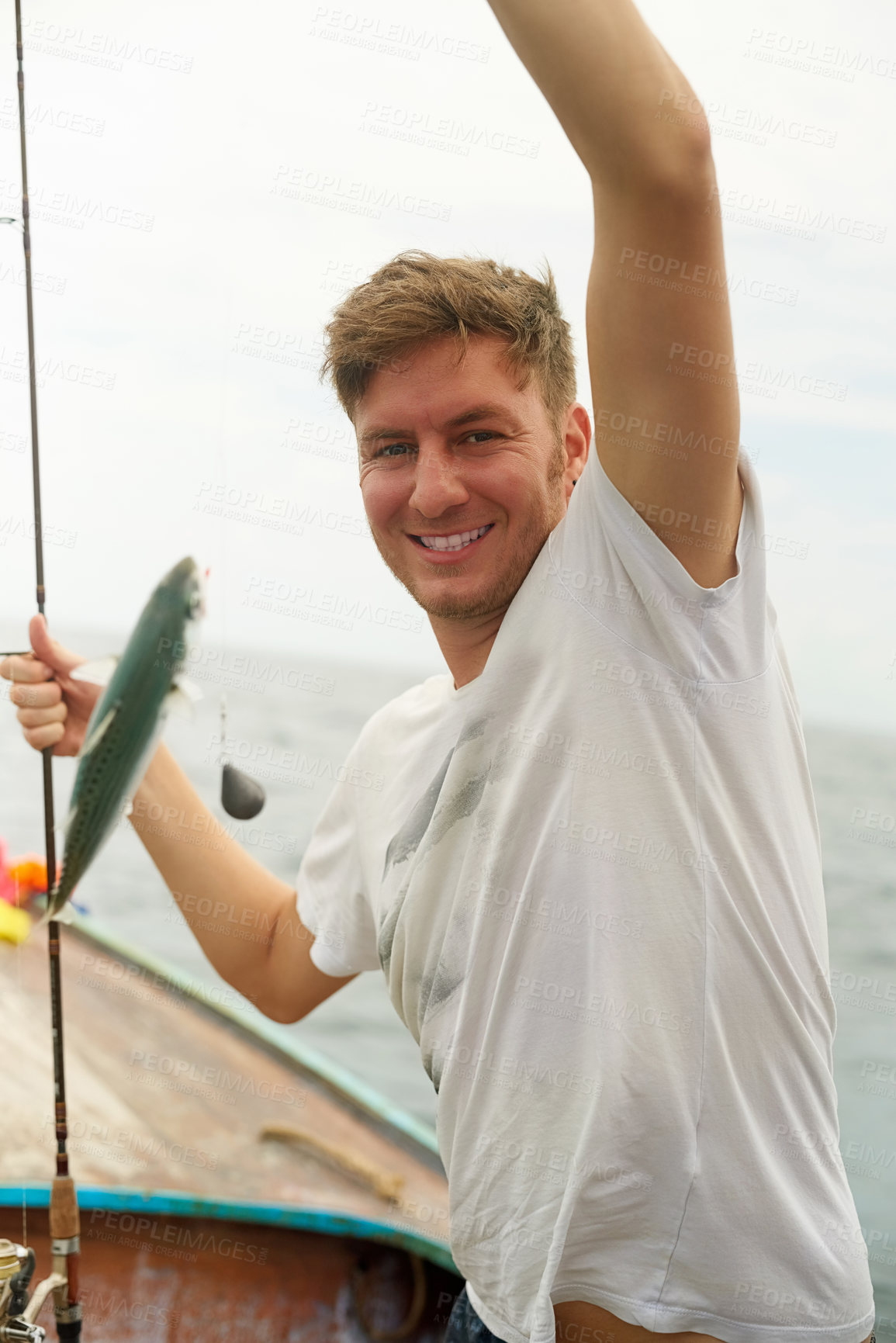Buy stock photo Cropped portrait of a handsome young man fishing while out at sea on his boat
