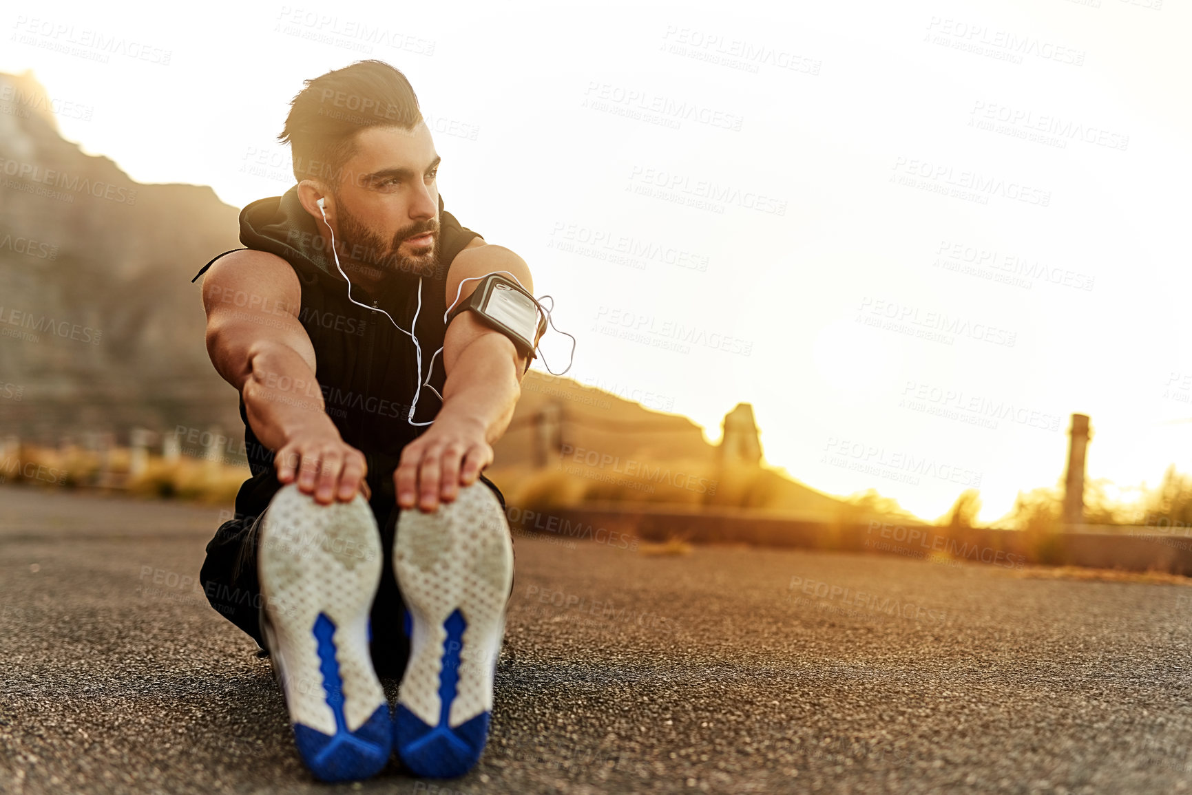 Buy stock photo Man, fitness and headphones with stretching of legs on ground for exercise, workout or warm up music. Male person, idea and runner on mountain with preparation for muscle, training or sports podcast