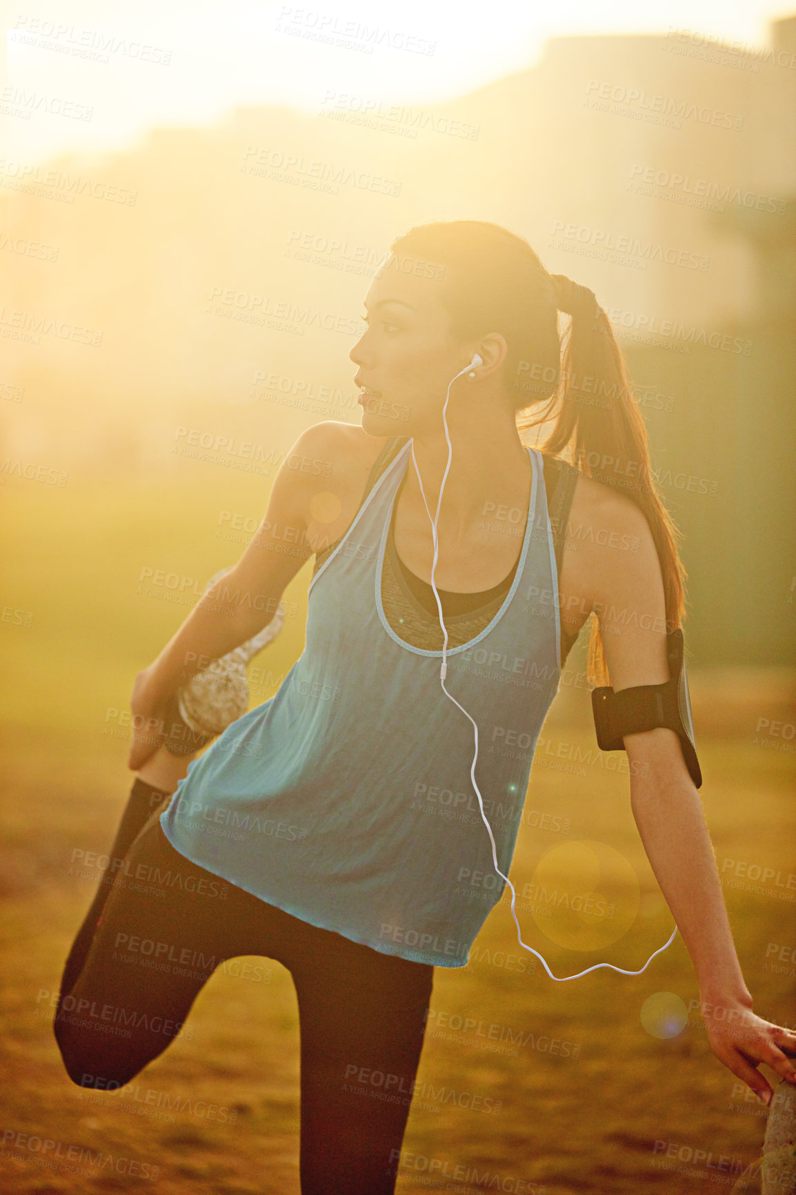 Buy stock photo Shot of a sporty young woman stretching before her run