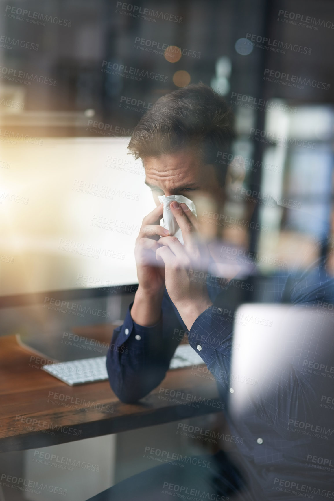 Buy stock photo Sneeze, tissue and business man blowing nose in office for sick, virus infection or flu bacteria. Lens flare, administrator and  employee at desk with computer for disease, congestion or hay fever