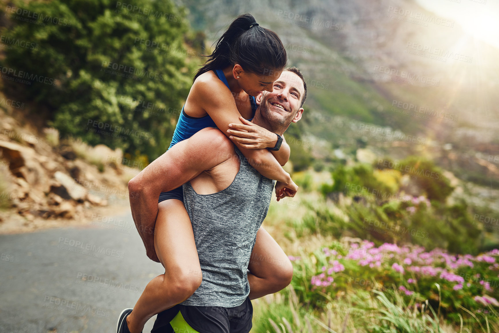 Buy stock photo Happy couple, exercise and piggyback with smile in nature for marathon training, cardio workout or challenge. Sunshine, sports and man carrying woman on mountain for fitness, wellness or endurance