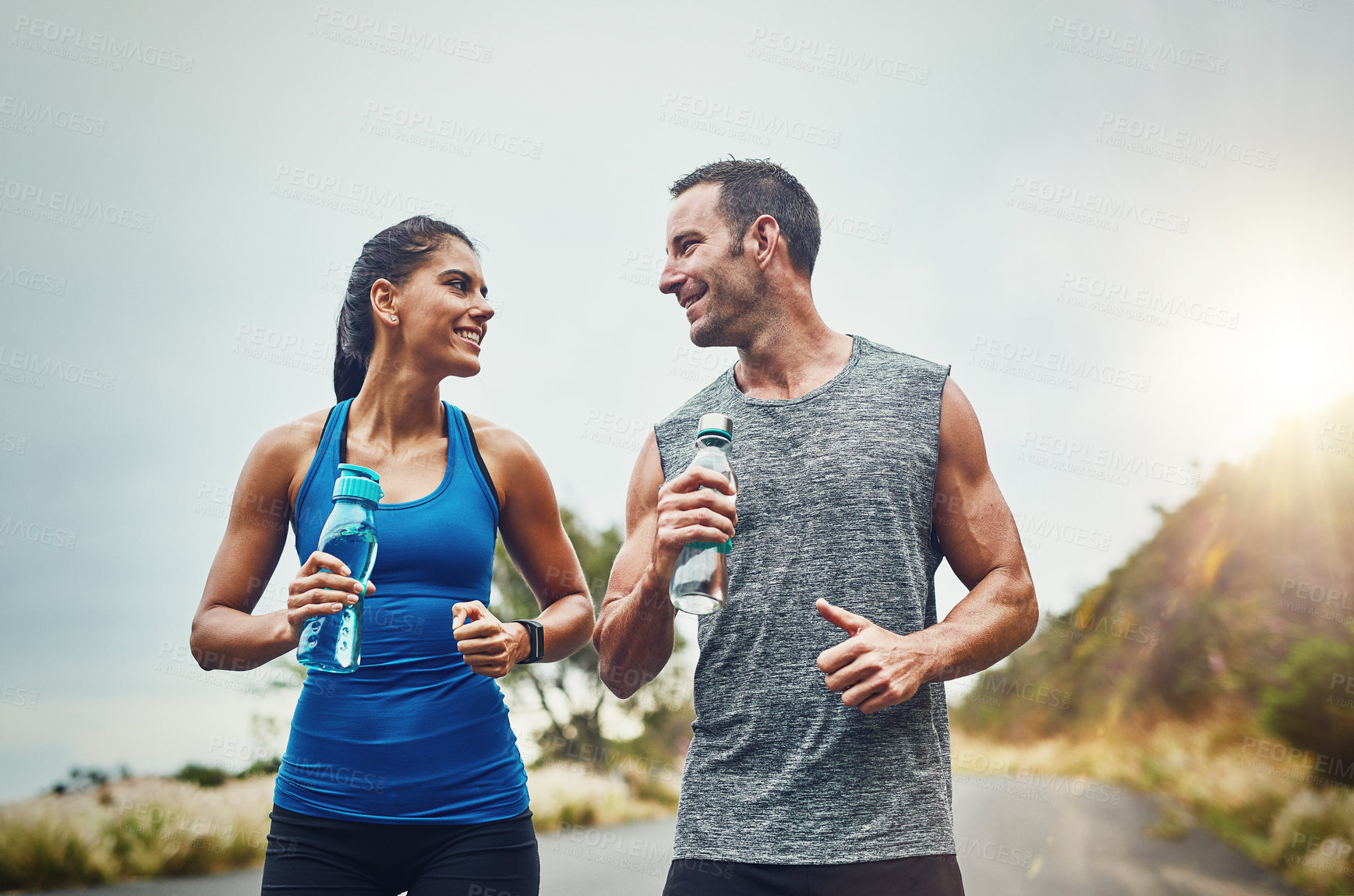 Buy stock photo Fitness, runner or happy couple drinking water on break to hydrate or relax for healthy energy in exercise. Tired, people and thirsty athletes with liquid or hydration in marathon training or workout