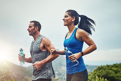 Buy stock photo Energy, running and couple for outdoor exercise with water bottle, fitness adventure and training for sport competition. Runner team, man and woman in nature for cardio workout and marathon challenge