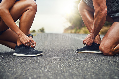 Buy stock photo Couple, exercise and tie lace together on road for outdoor marathon, running and training as team. People, wellness and sports shoes outside for health, fitness and adventure or collaboration