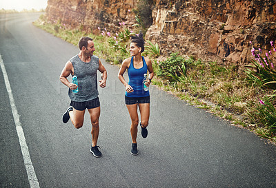 Buy stock photo Couple, road and smile with running for fitness or training, support and love in California. Workout, exercise and people with jogging for health or wellness and wellbeing in morning with happiness