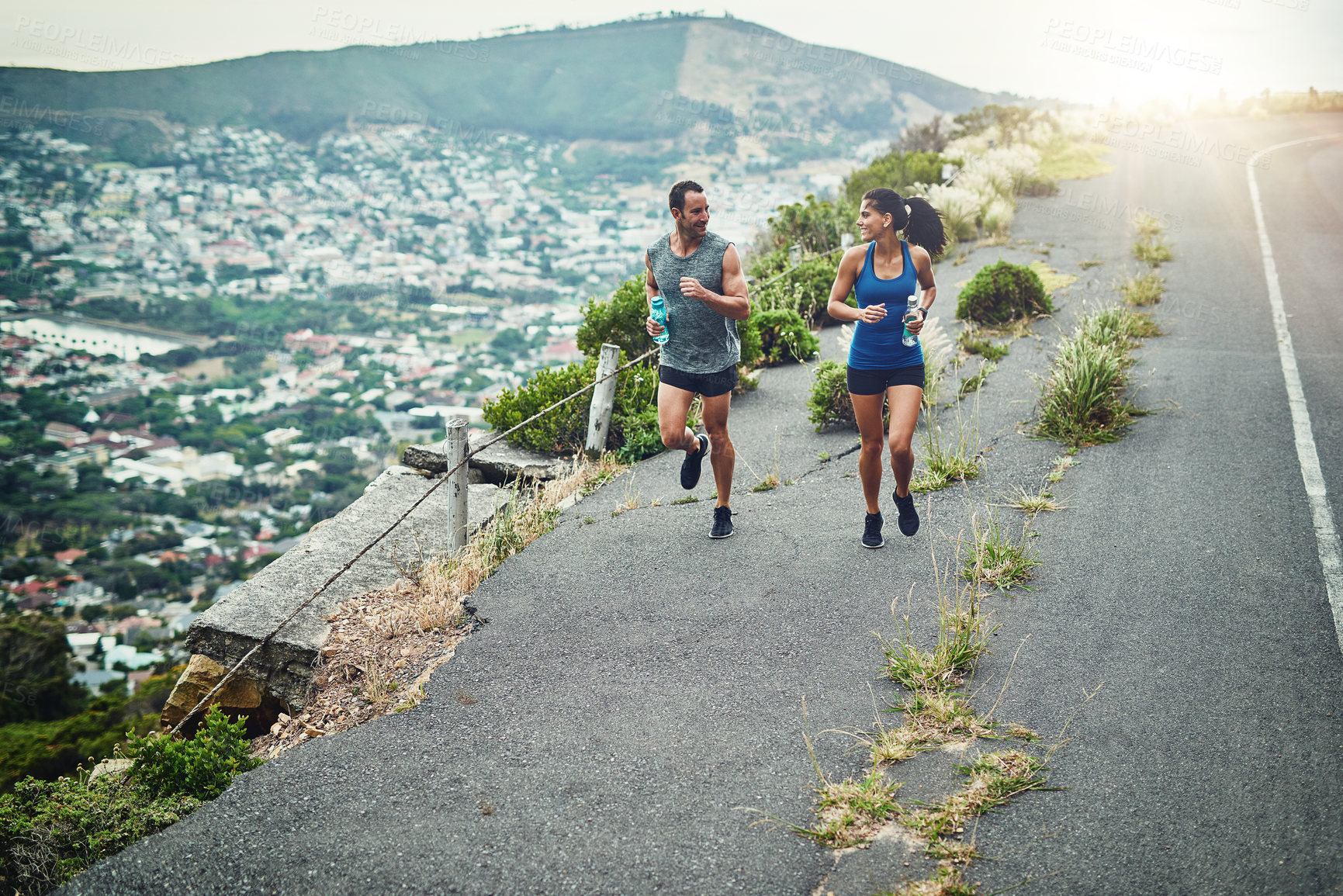 Buy stock photo Fitness, running and couple with smile, road and bottle for hydration with water and outdoor. Exercise, race and people in morning, sportswear and training together, energy and workout in routine