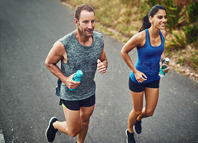 Buy stock photo Fitness, running and couple with smile, marathon and bottle for hydration with water and outdoor. Road, race and people in morning, sportswear and training together, energy and workout for exercise