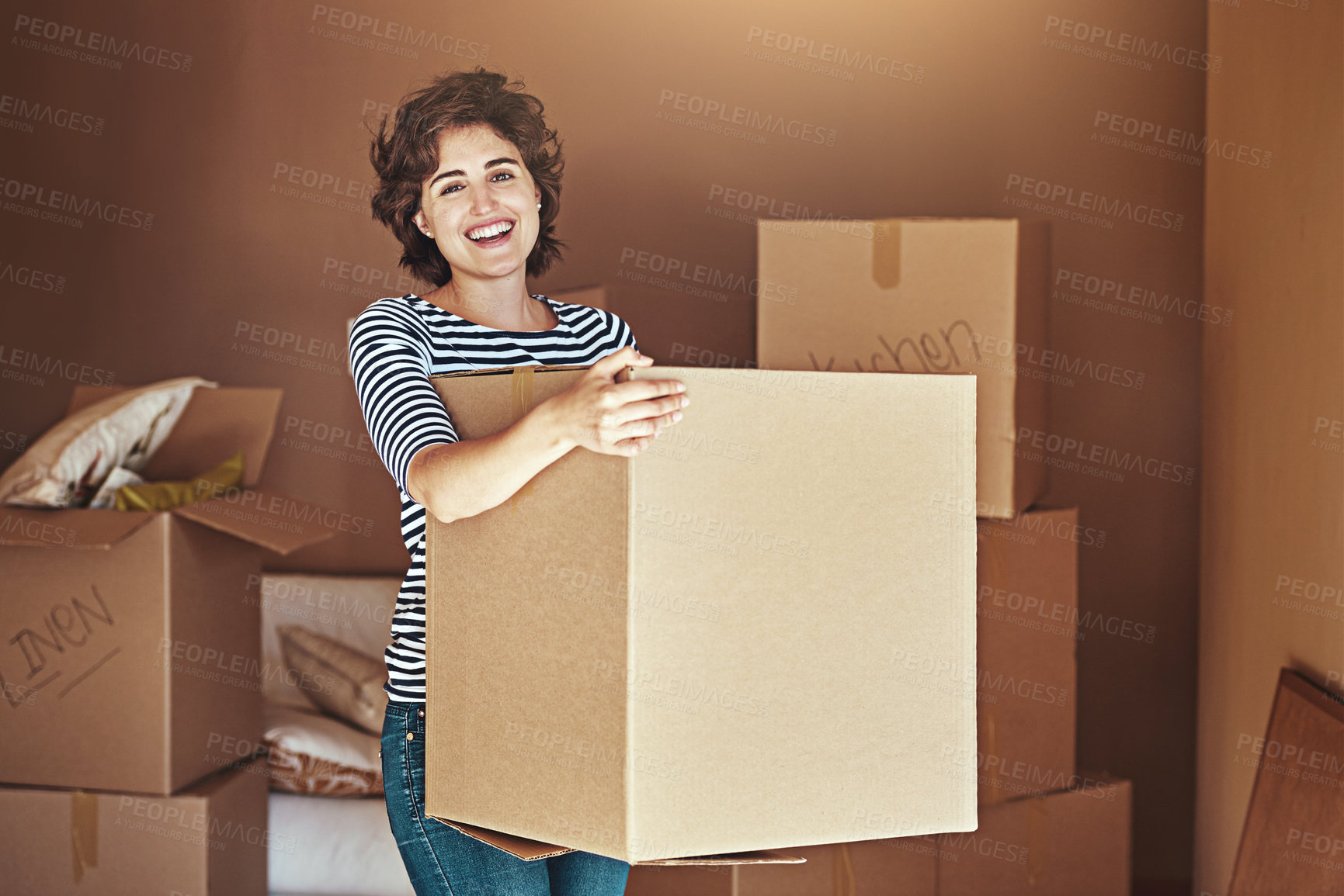 Buy stock photo Shot of a young woman packing up on moving day