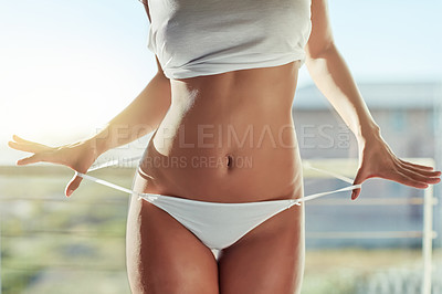 Buy stock photo Cropped shot of an unrecognizable young woman removing her underwear on the balcony
