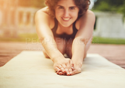 Buy stock photo Shot of an attractive young woman practicing yoga outdoors