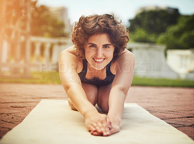 Buy stock photo Shot of an attractive young woman practicing yoga outdoors