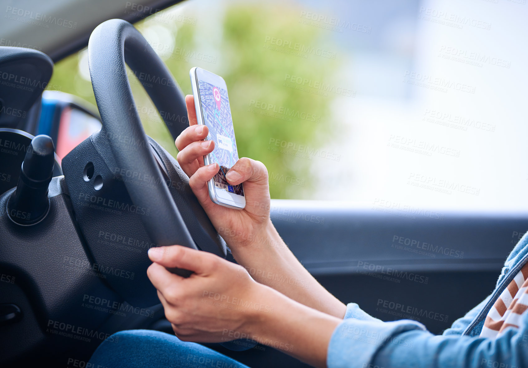 Buy stock photo Cropped shot of a woman using her phone’s gps system while driving a car